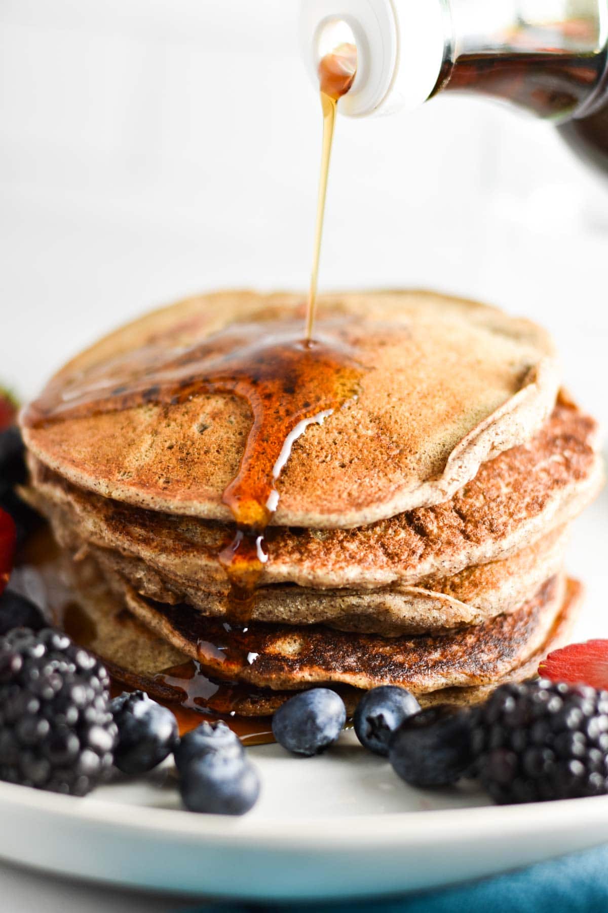 Syrup poured on top of buckwheat pancakes.