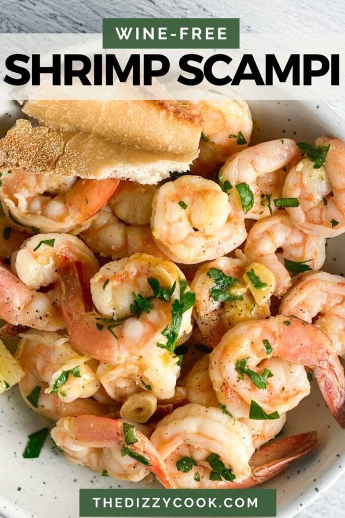Shrimp scampi in a white bowl with garlic and parsley.