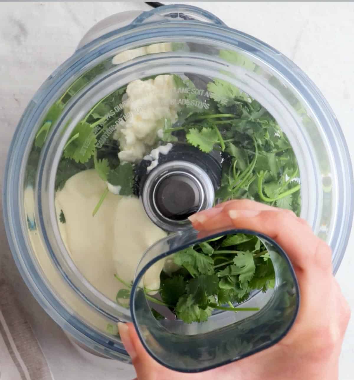Using a food processor to blend the sauce.