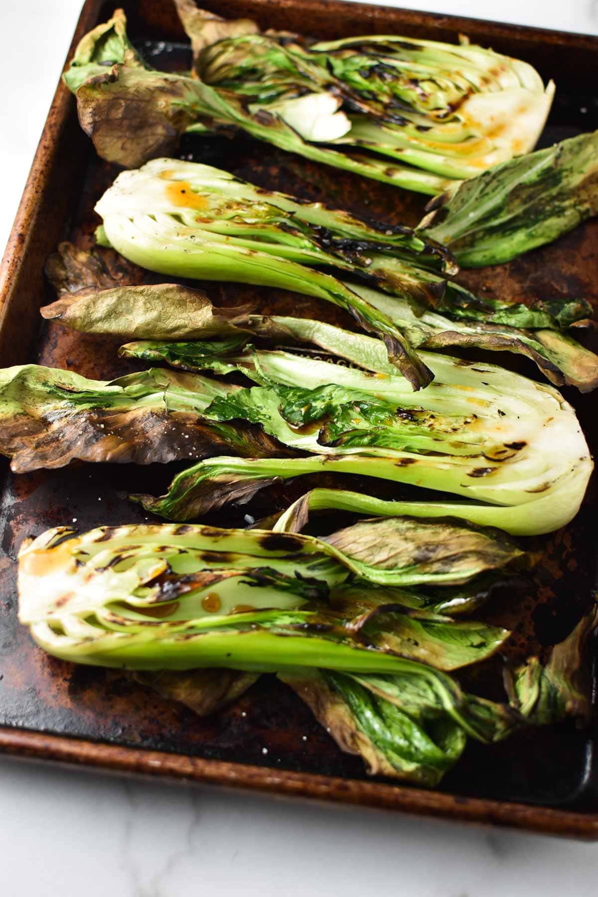 A sheet pan of grilled bok choy.