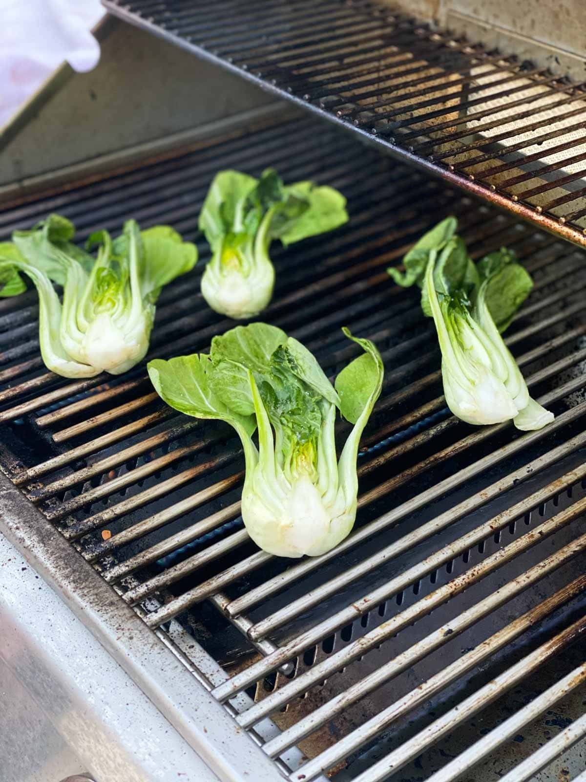 Four bok choy on a grill.