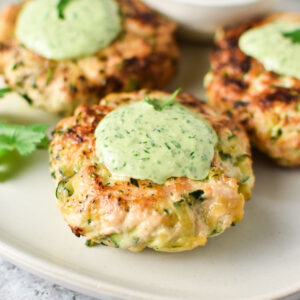 Chicken zucchini poppers topped with a green cilantro sauce.