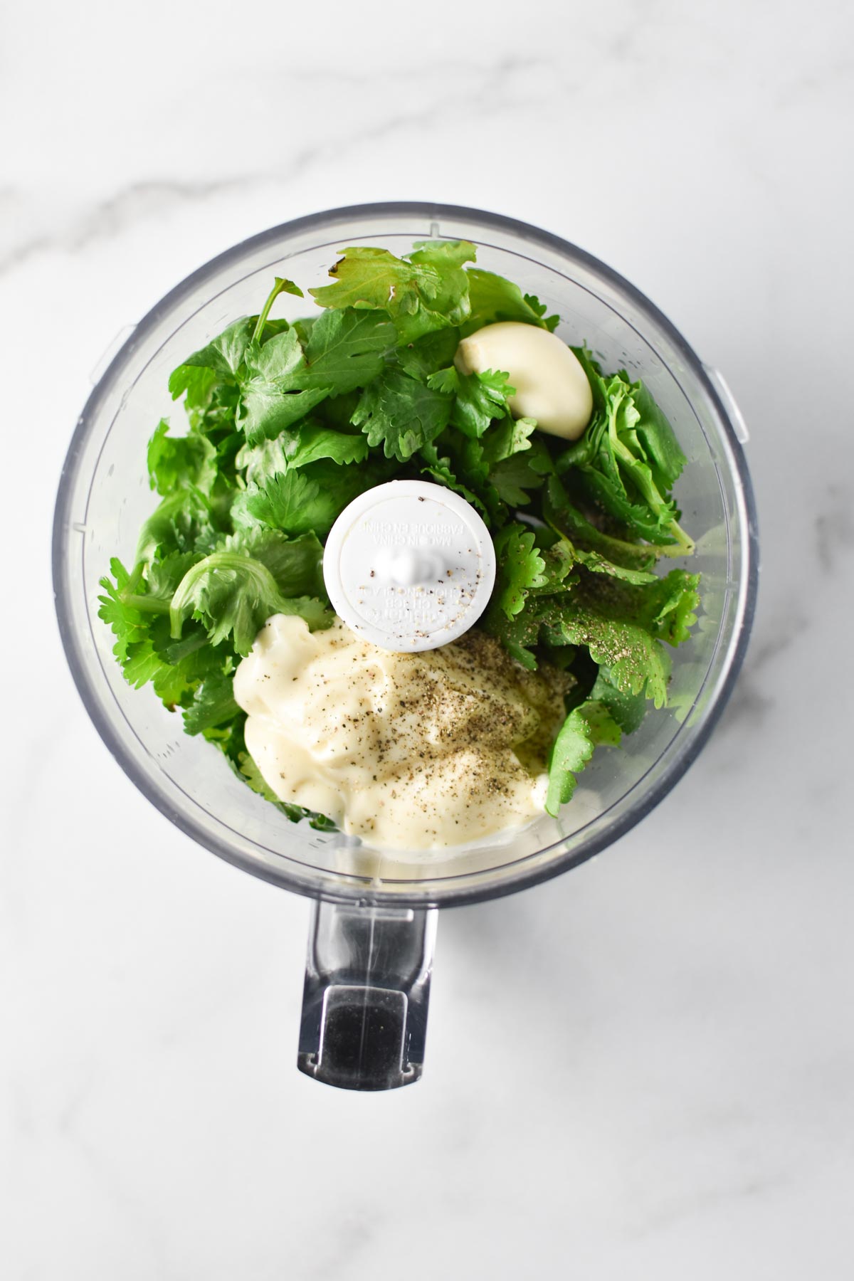 Creamy cilantro sauce ingredients in a food processor.