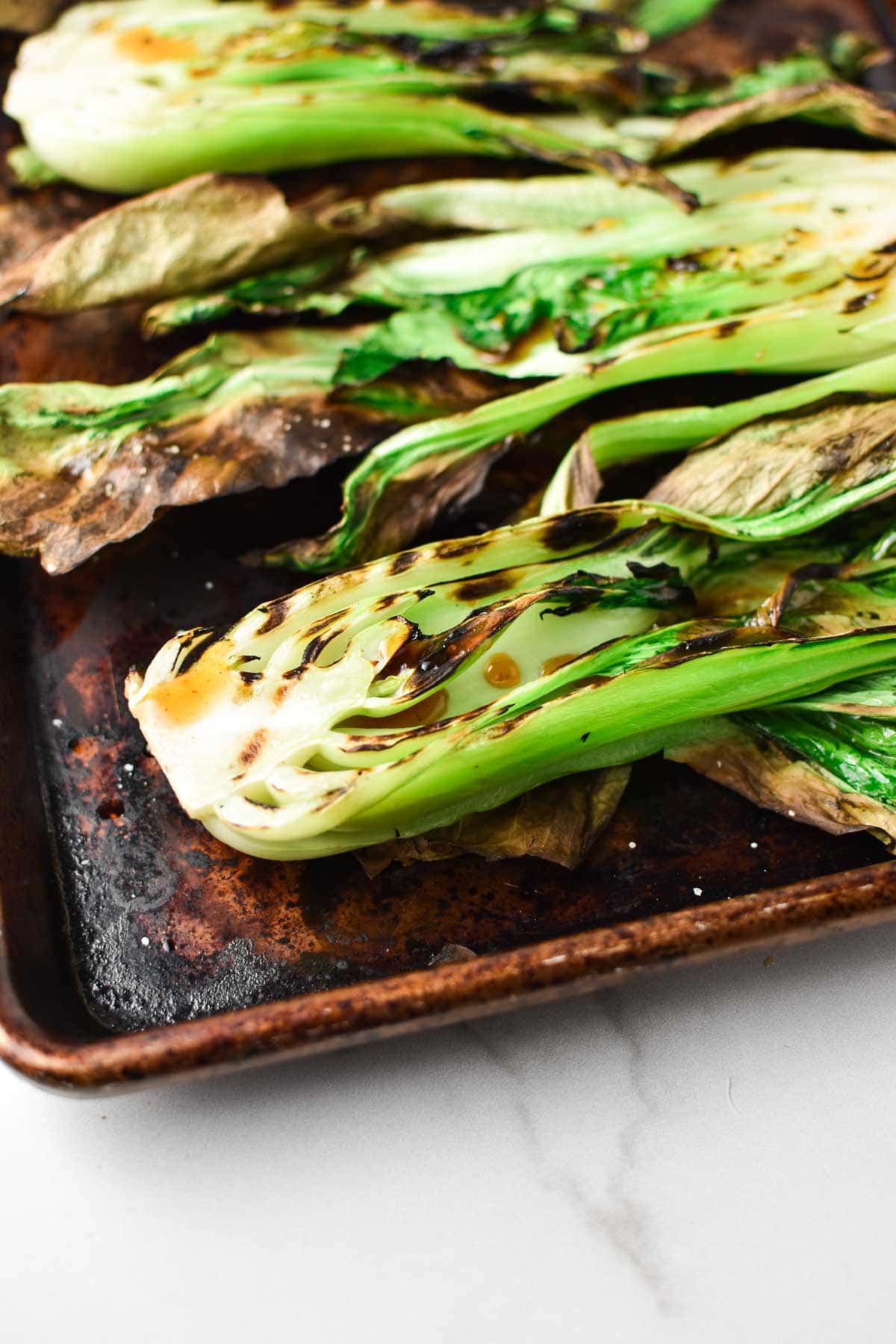 Bok choy with grill marks covered in sweet chili sauce.