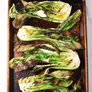 Grilled baby bok choy on a sheet pan.