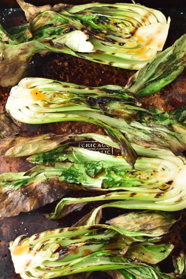 Grilled baby bok choy on a sheet pan.