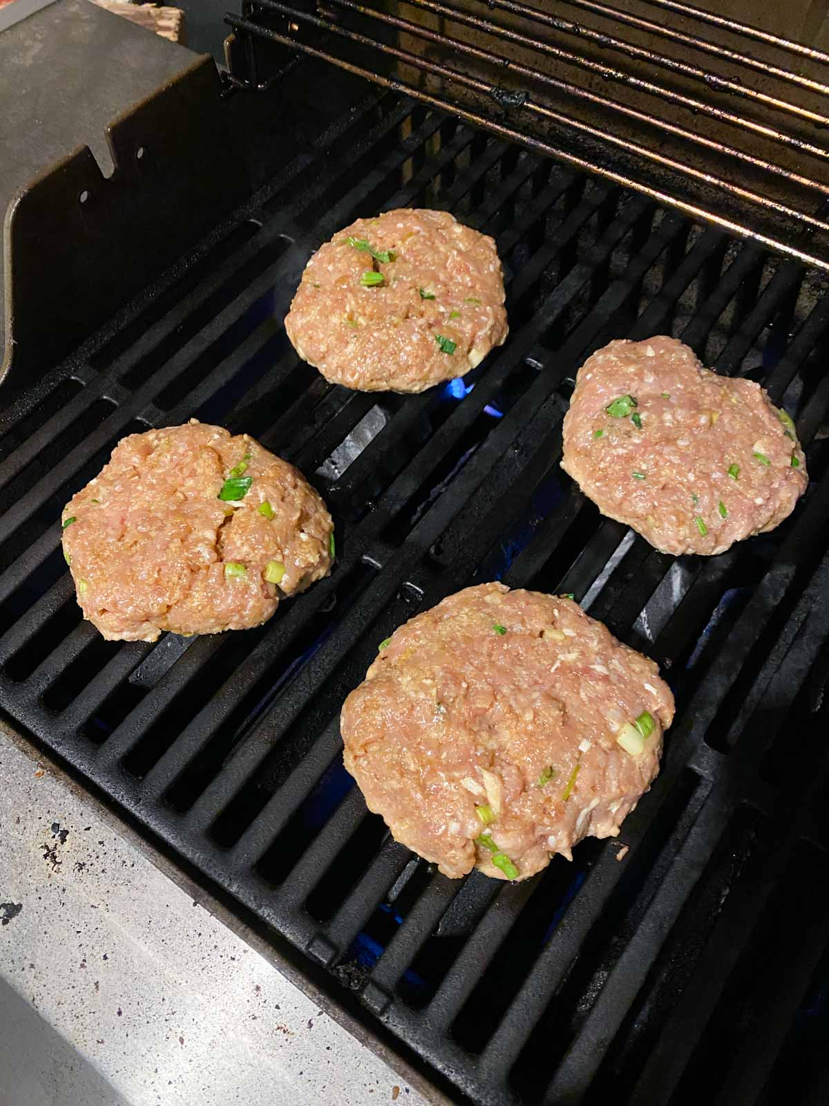 Chicken burgers on a gas grill.