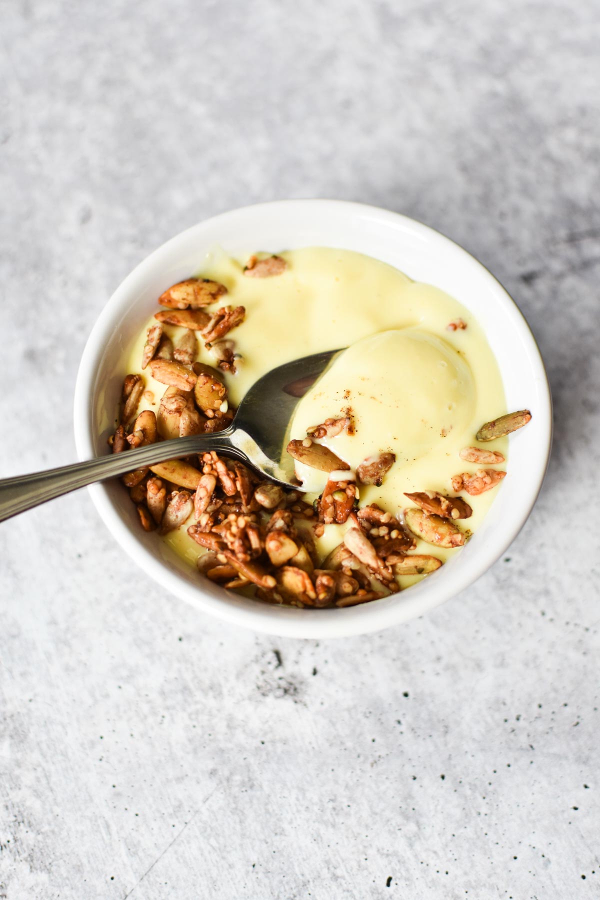 A spoon dipping into a mango smoothie bowl.