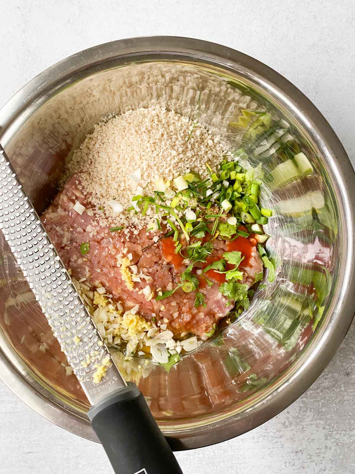 Mixing the teriyaki ingredients with raw chicken.