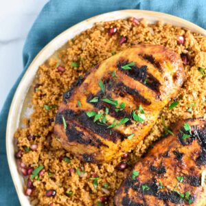 Grilled chicken breasts on a bed of couscous.