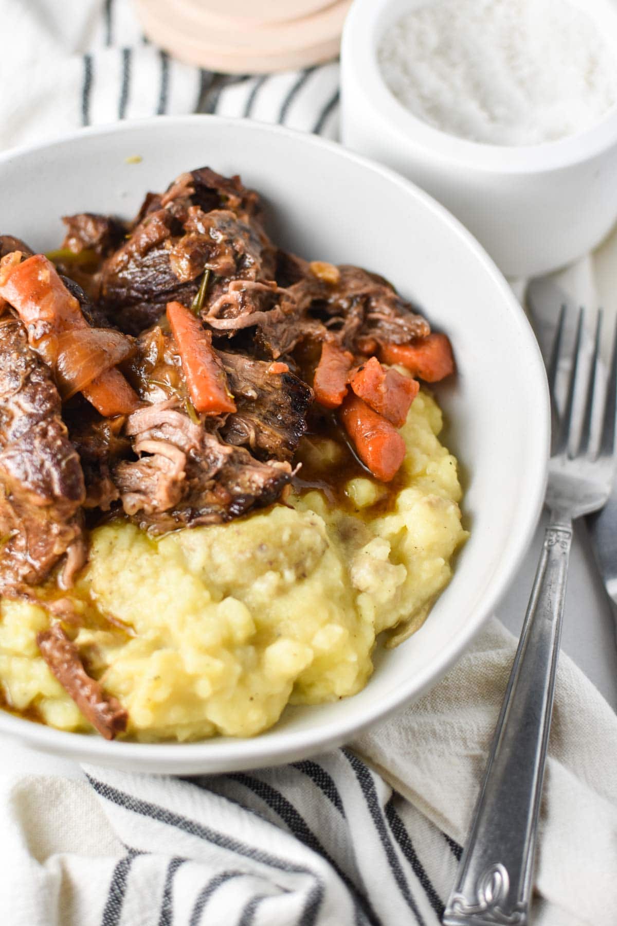 Pot roast in a bowl with potatoes and carrots. 