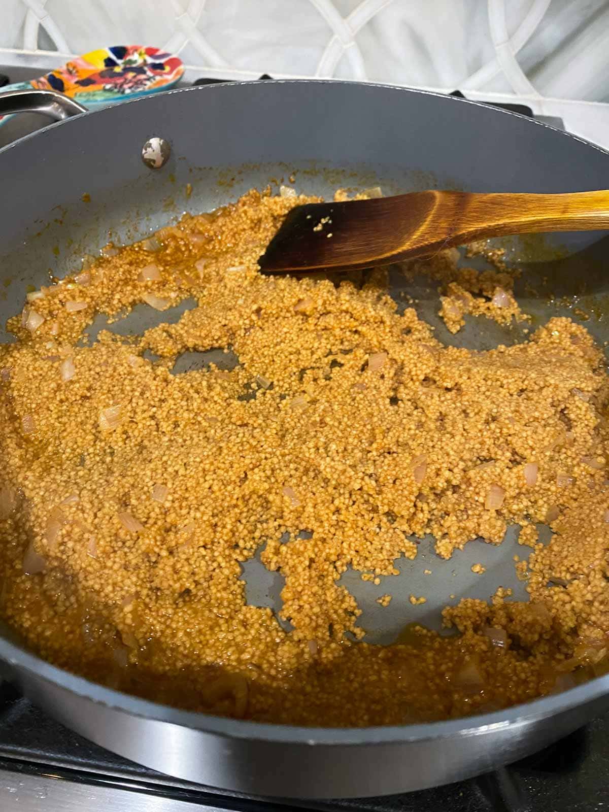 Stirring couscous into broth.