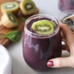 A blueberry smoothie topped with kiwi.