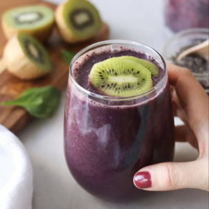 A blueberry smoothie topped with kiwi.