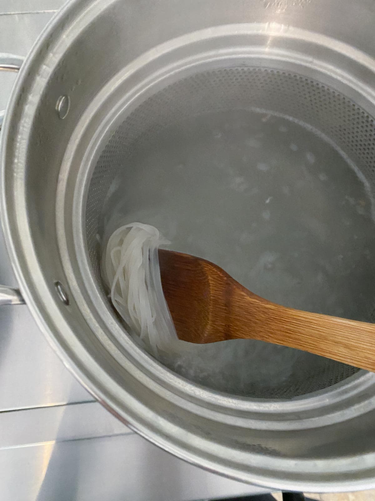 Boiling rice noodles in a big pot.