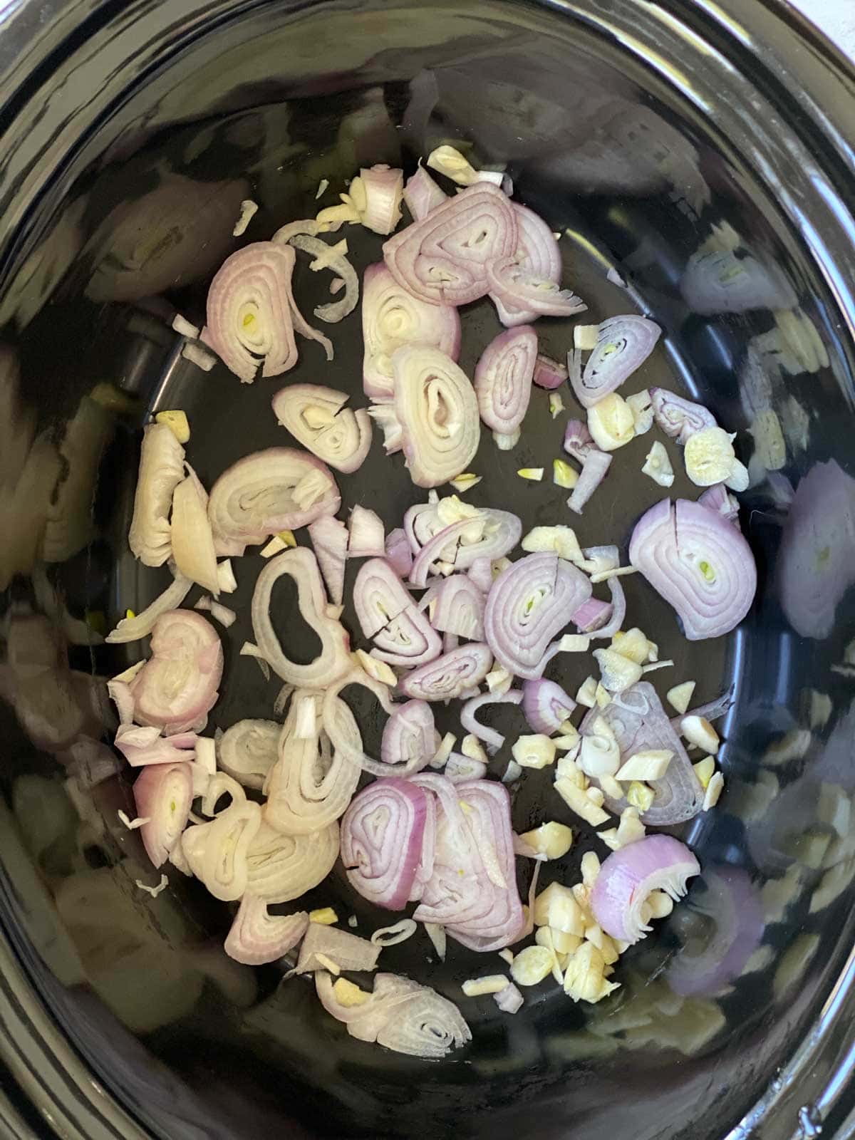 Shallots and garlic in a slow cooker.