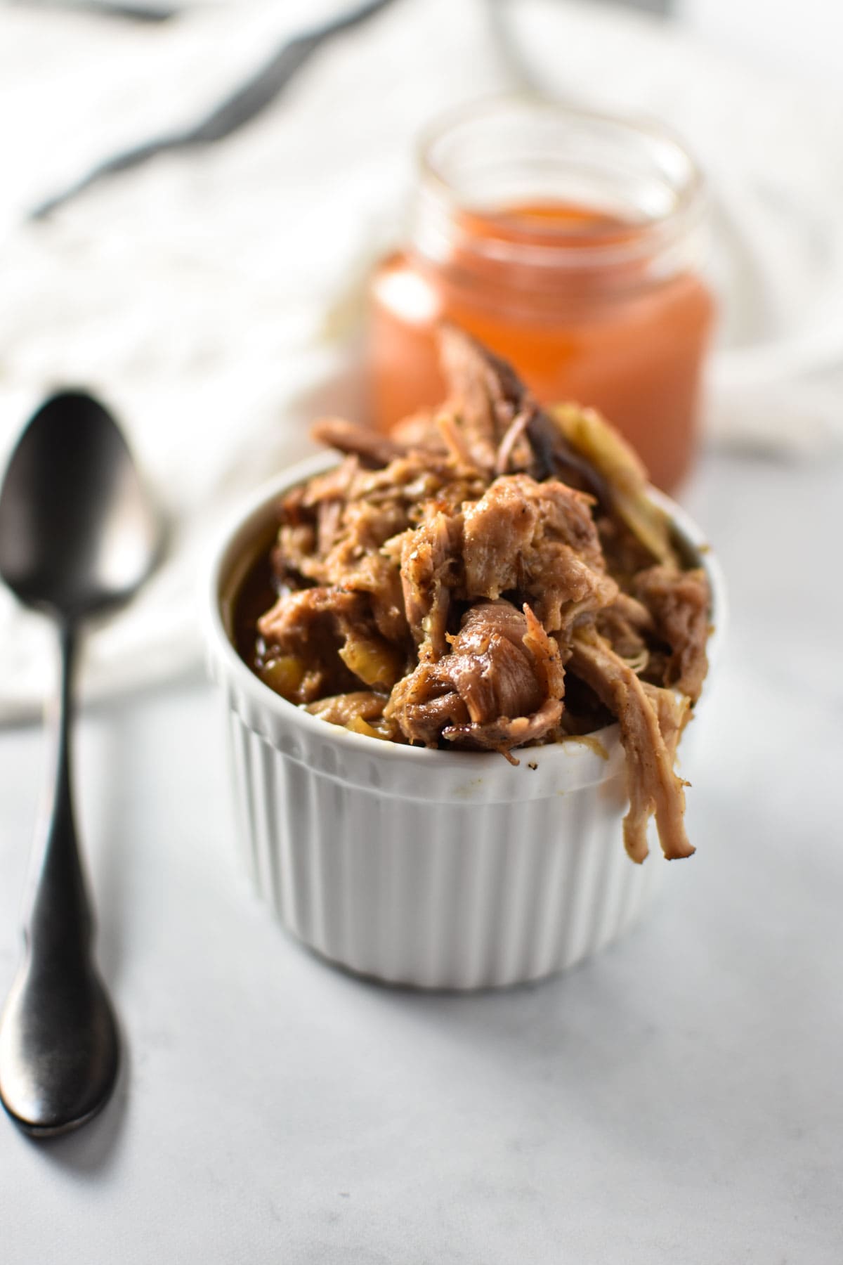 Pulled pork shoulder in a white dish. 