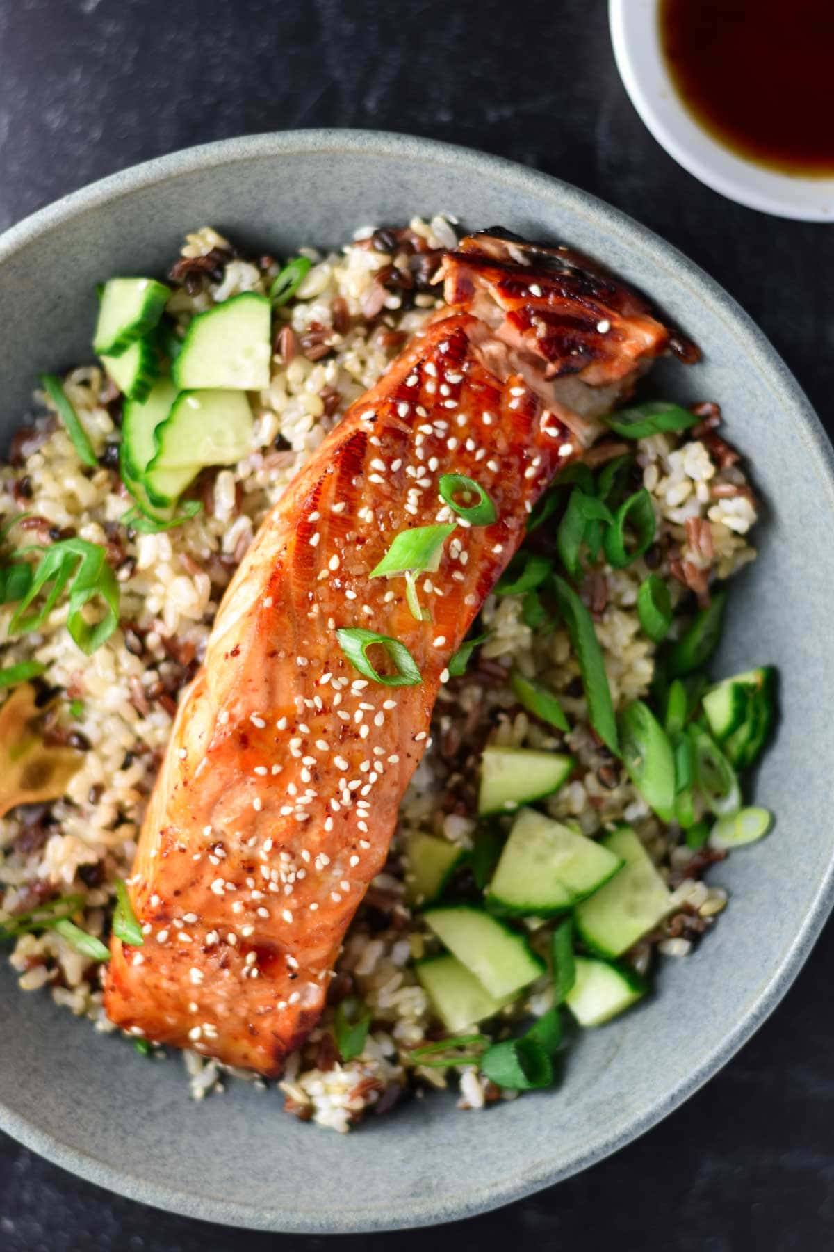 Sweet chili salmon on a bed of rice topped with sesame seeds. 