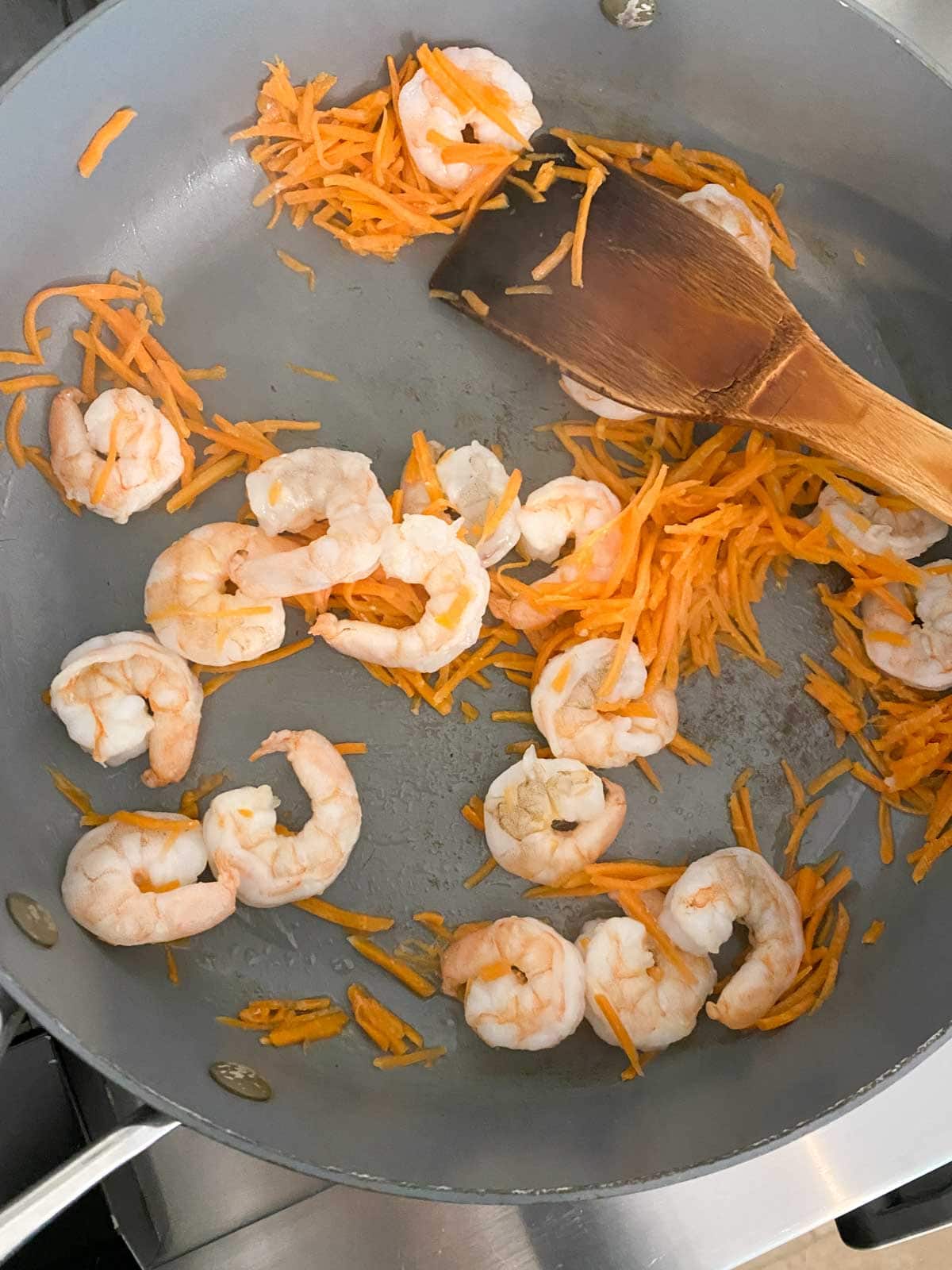 Cooking shrimp and vegetables in a big pan.