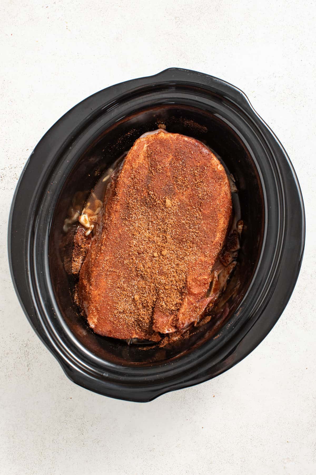 Dry rub on a pork shoulder in a crock pot.