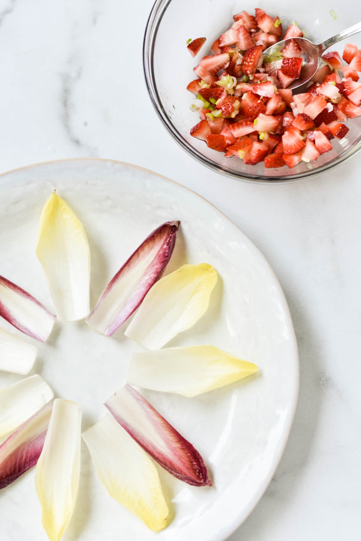 Endive boats and strawberry relish on a table.