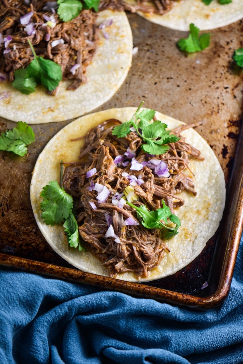 A juicy shredded flank steak taco on a baking sheet.