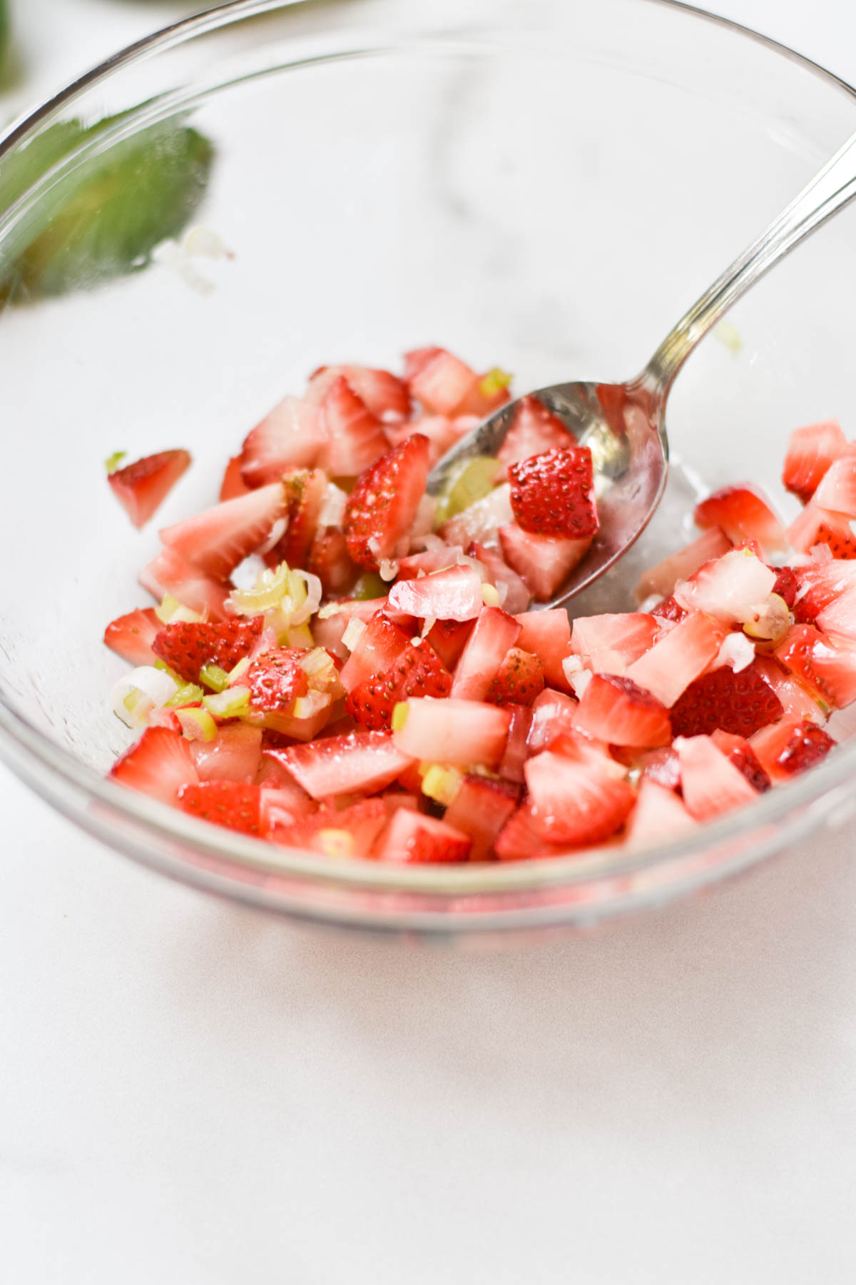 A spoon mixing strawberry relish.