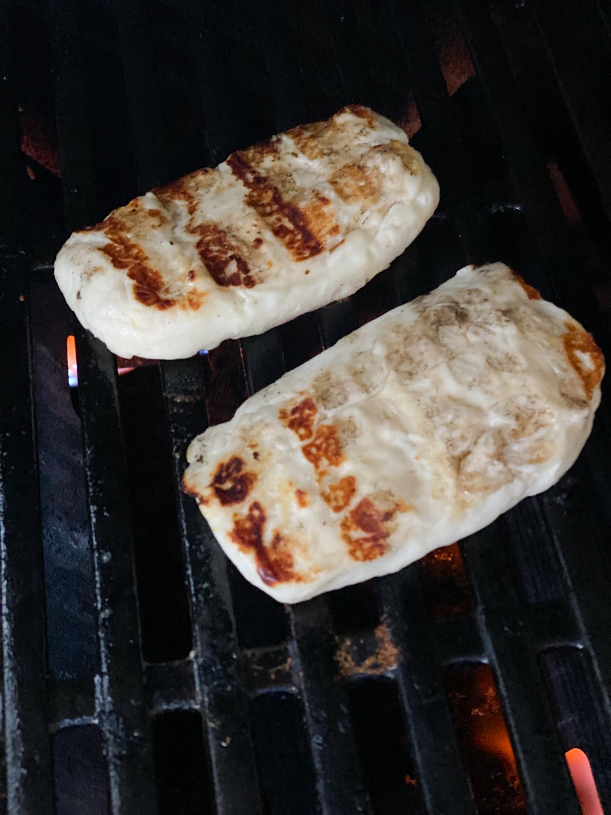 Halloumi with grill marks on a grill.