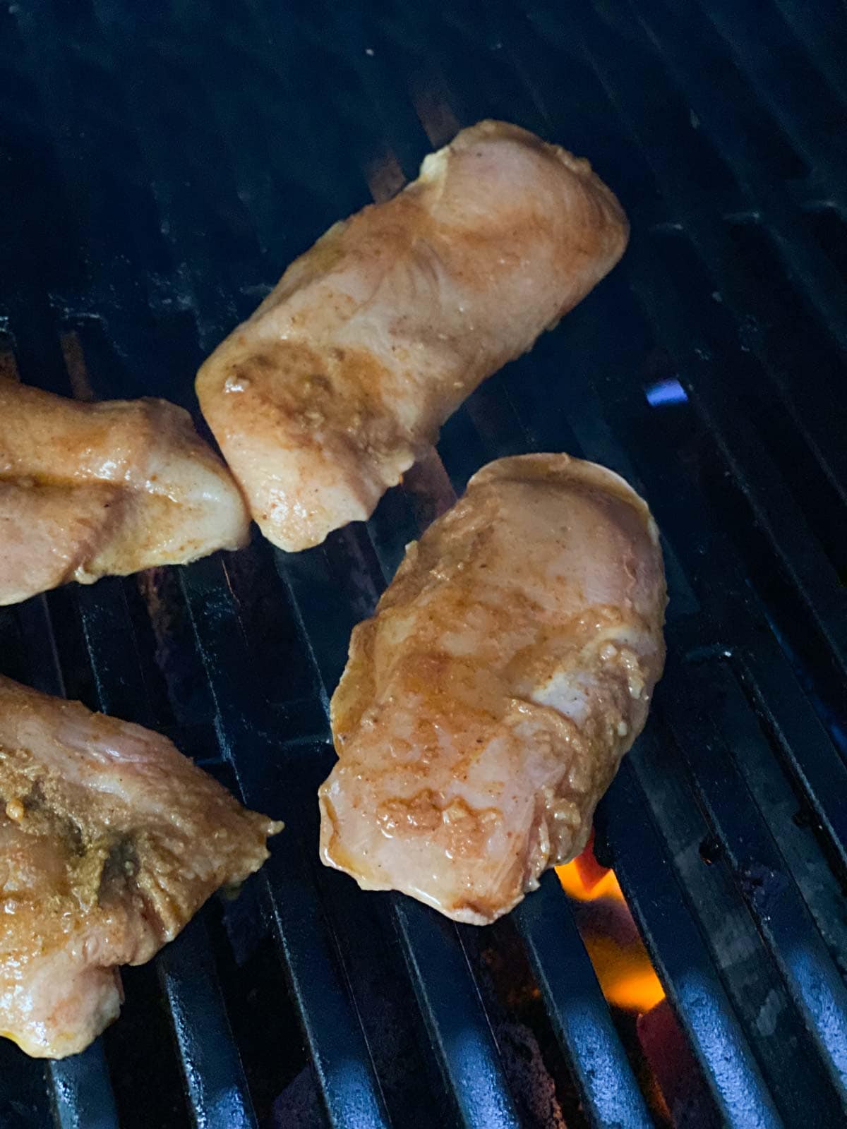 Raw chicken placed on grill.