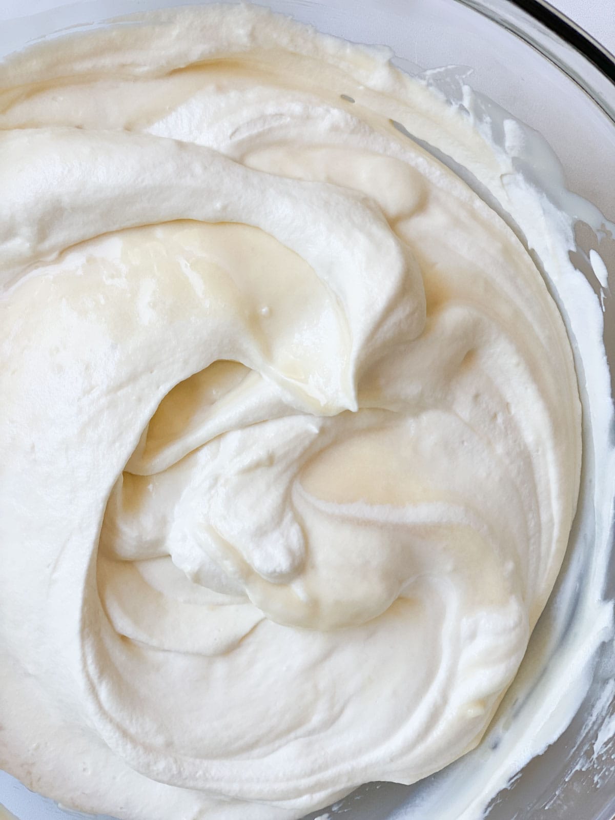 Whipping cream combined with an ice cream base in a bowl.