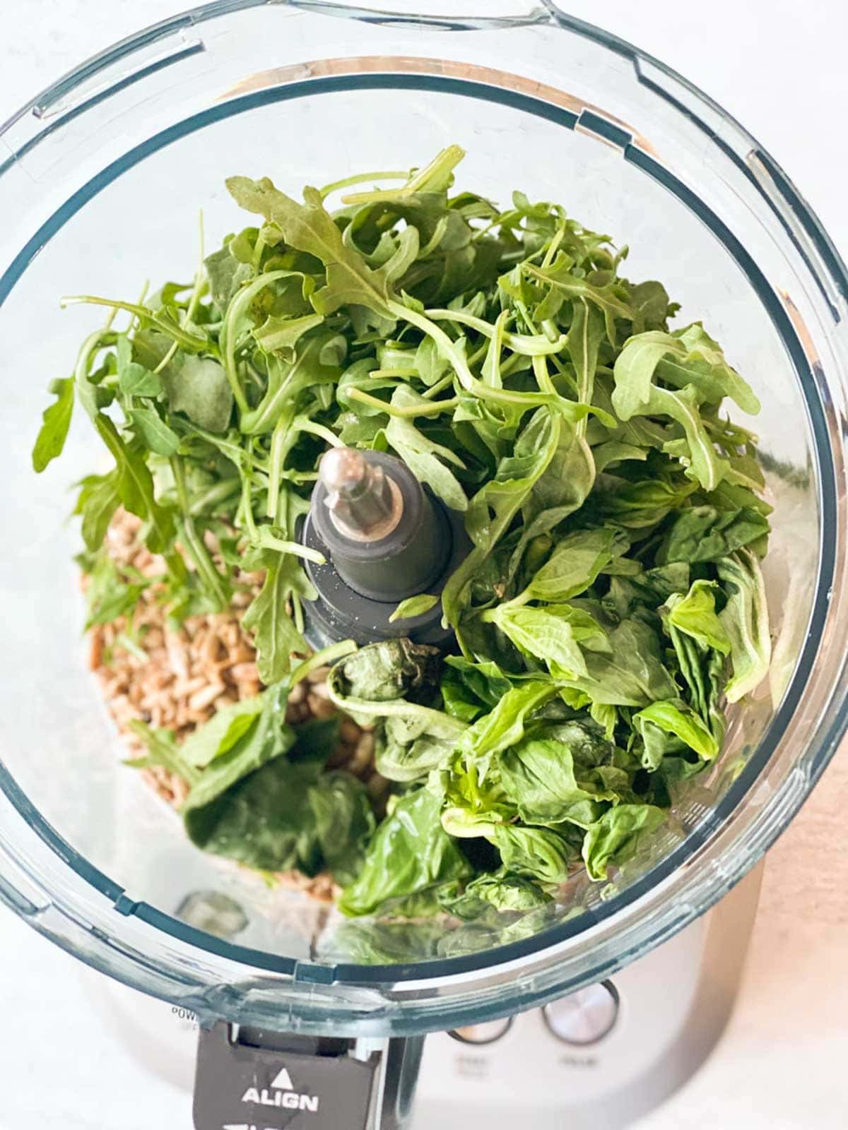 Ingredients for pesto in a food processor.