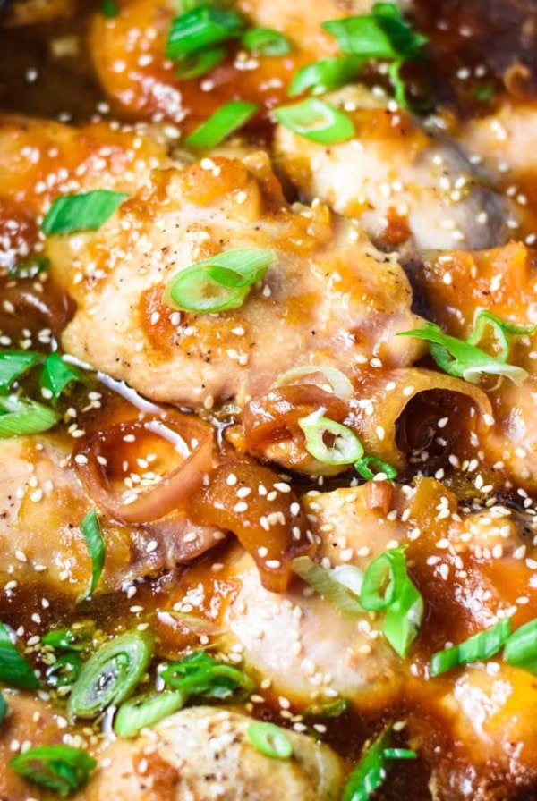 Apricot chicken in a slow cooker topped with green onion.