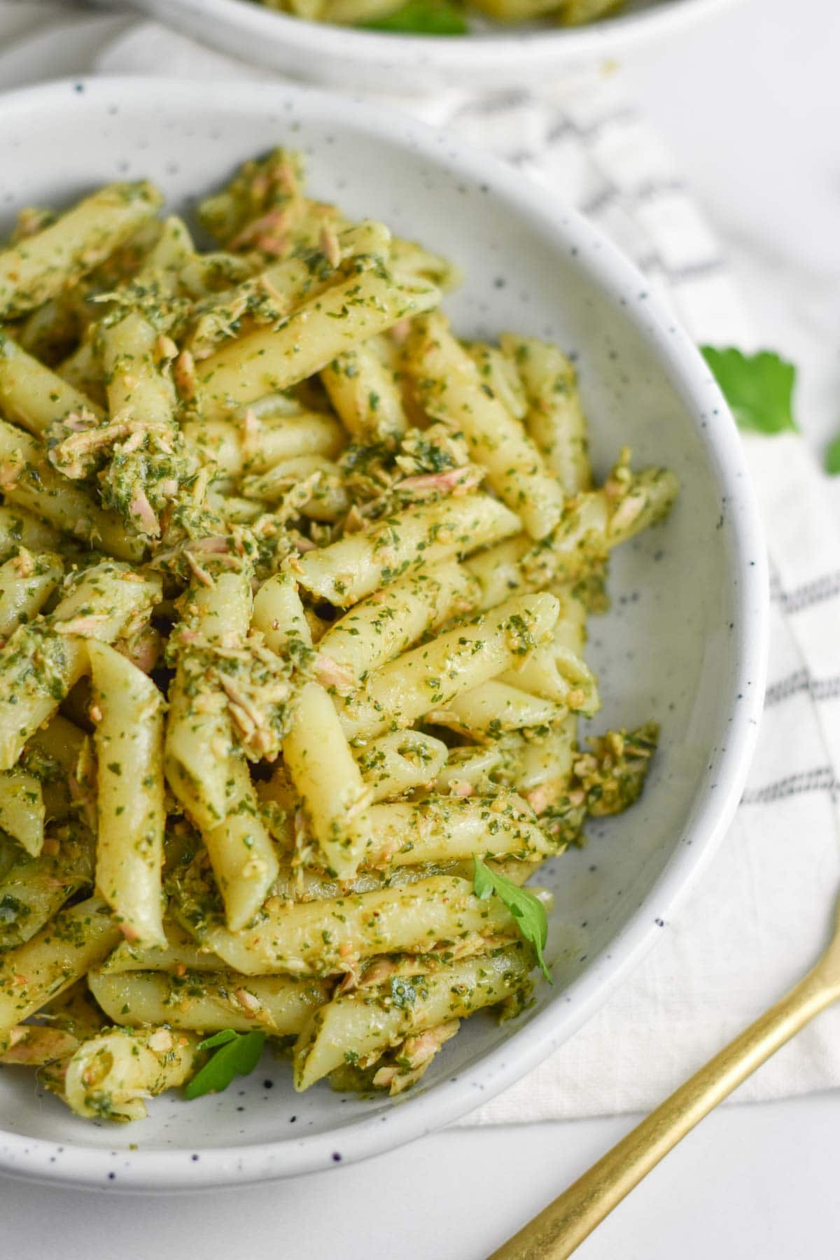 Tuna pesto pasta salad next to a fork.