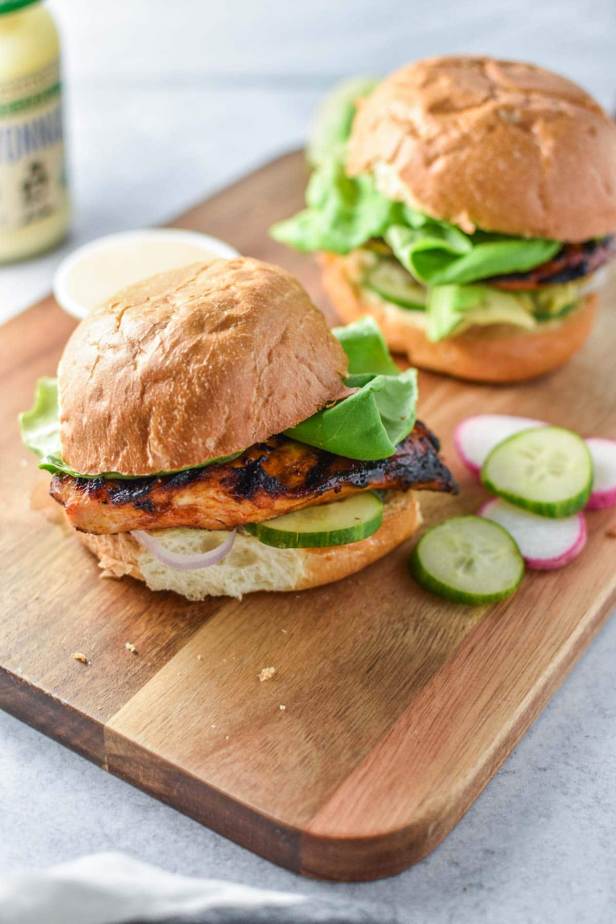 A chipotle chicken sandwich in front of mayo.