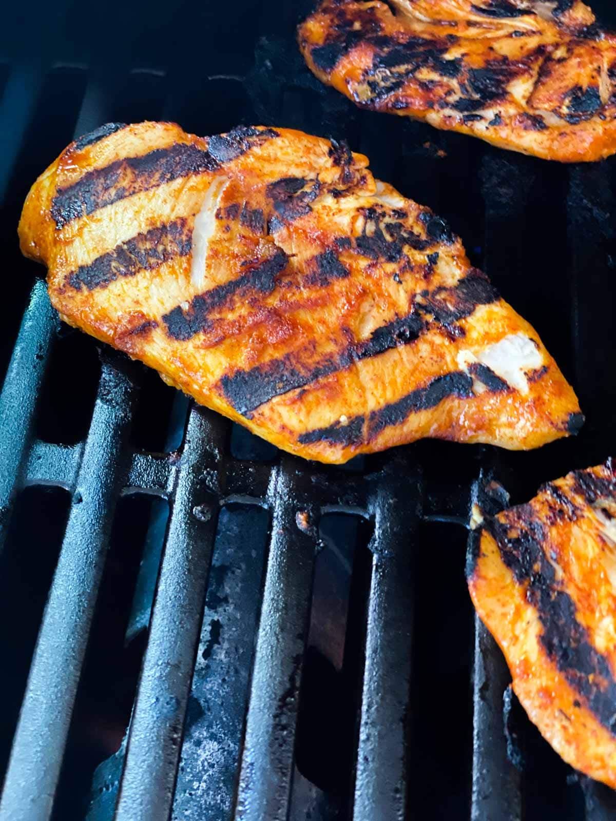 Grilled chicken breasts on a gas grill.