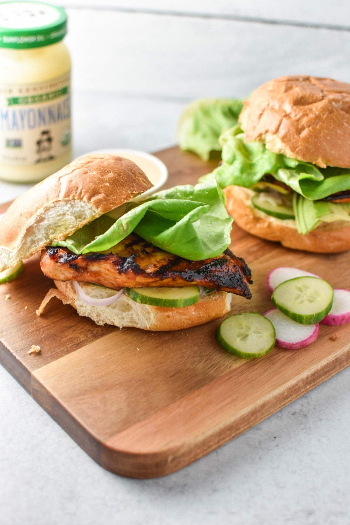 An open faced sandwich showing grilled chicken topped with lettuce.