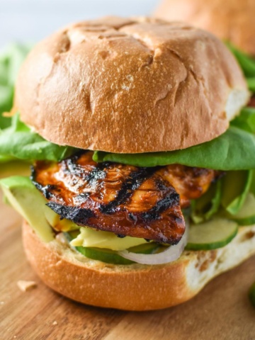 A honey chipotle chicken sandwich topped with lettuce and avocado.