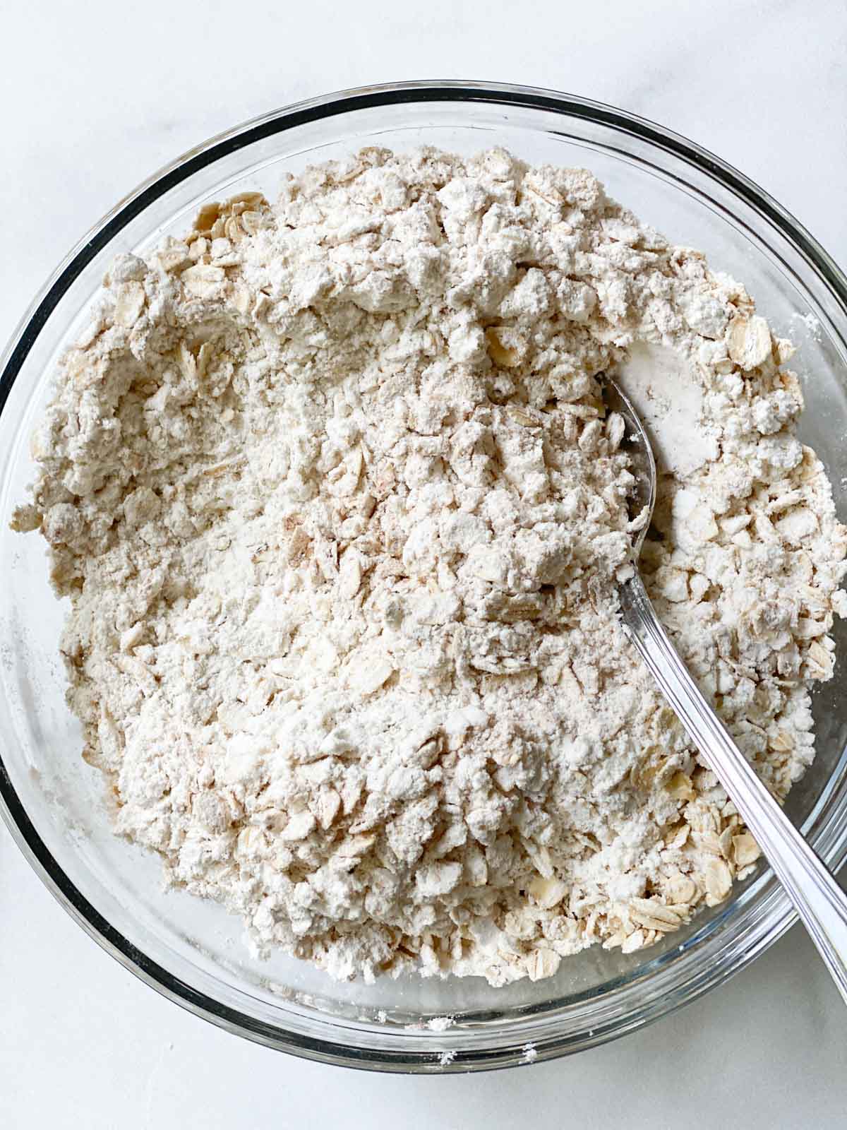 Mixing oats into dry ingredients.