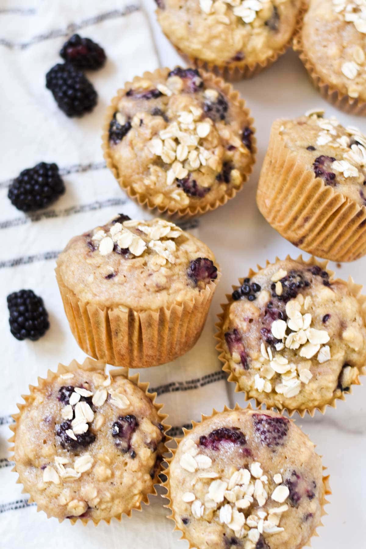 Side view of muffins with blackberries and oats.
