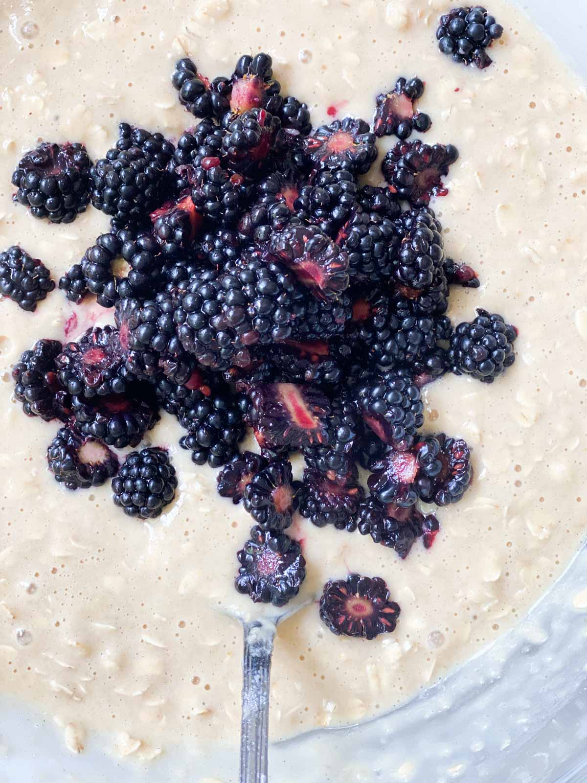 Stirring blackberries into muffin batter.