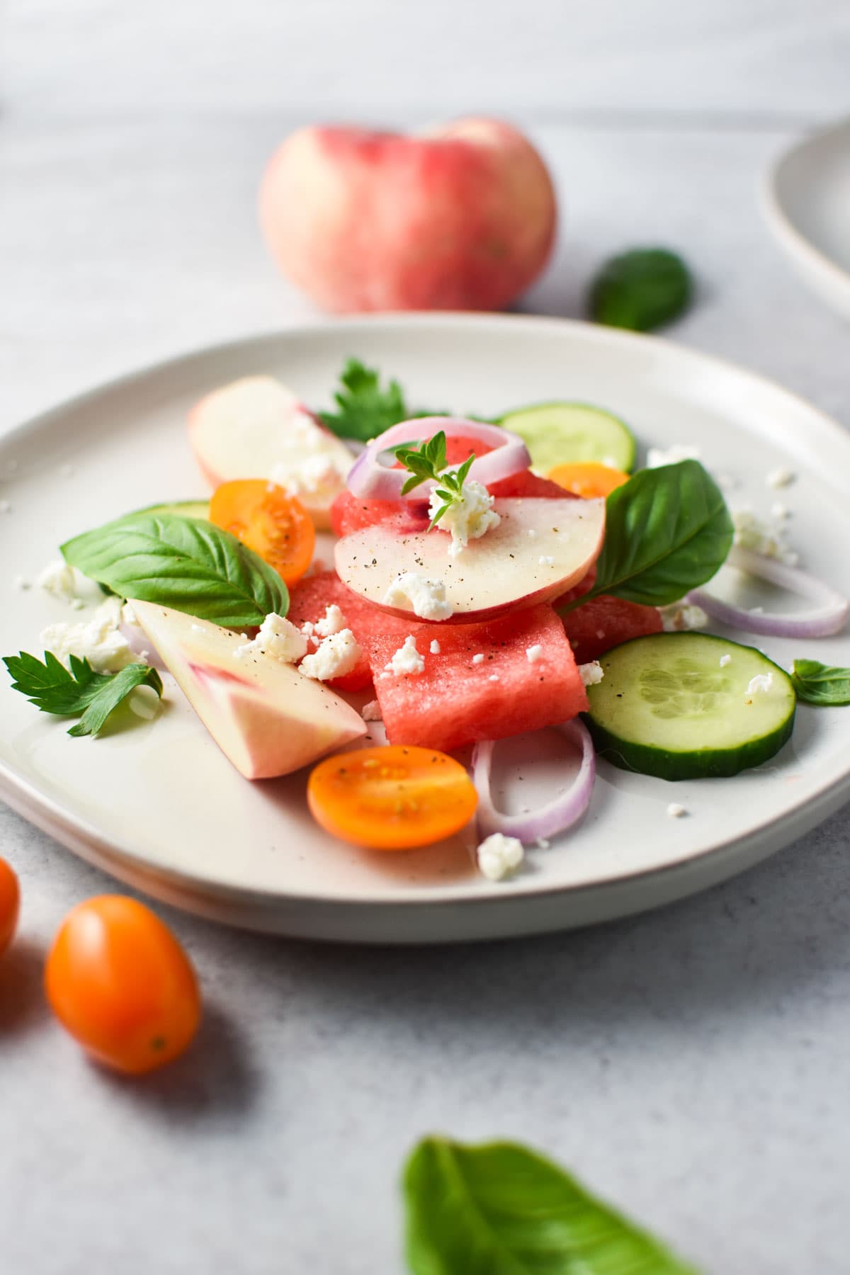 Watermelon stacked with goat cheese, cucumbers, and peaches.