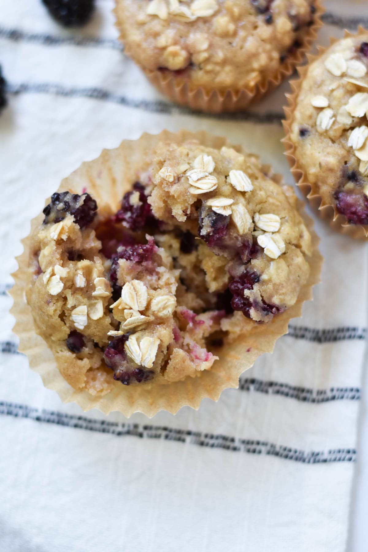 A muffin torn open to show the inside with blackberries.