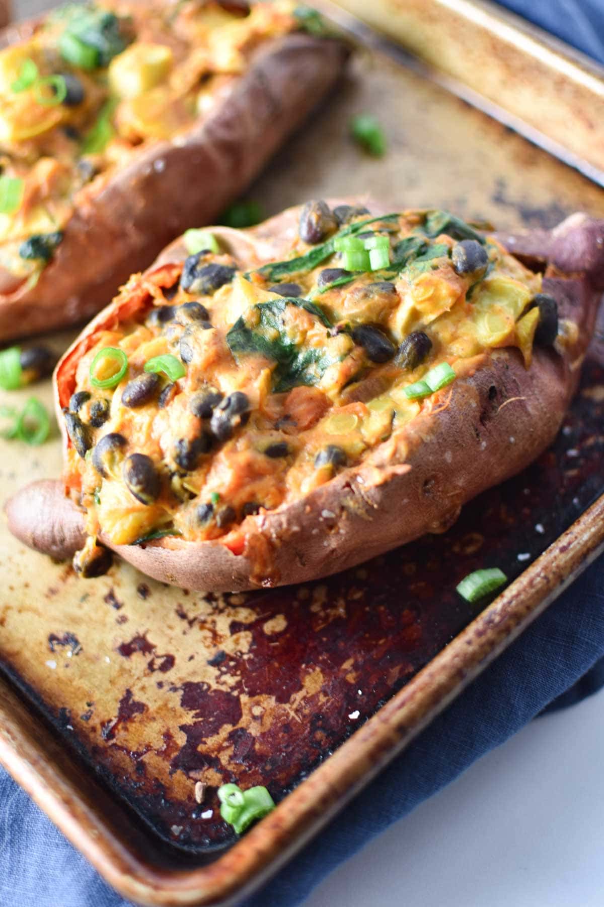 A vegetarian stuffed sweet potato on a sheet pan.