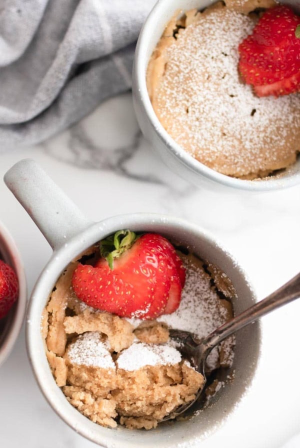 Powdered sugar on top of vanilla mug cakes.
