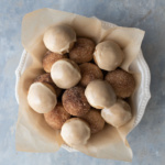 Baked donut holes in a bowl with parchment paper.
