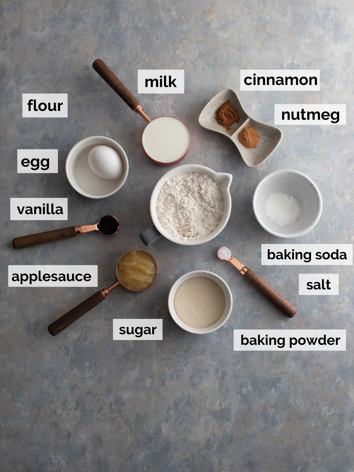 Flour, sugar, milk, and donut ingredients on a table.