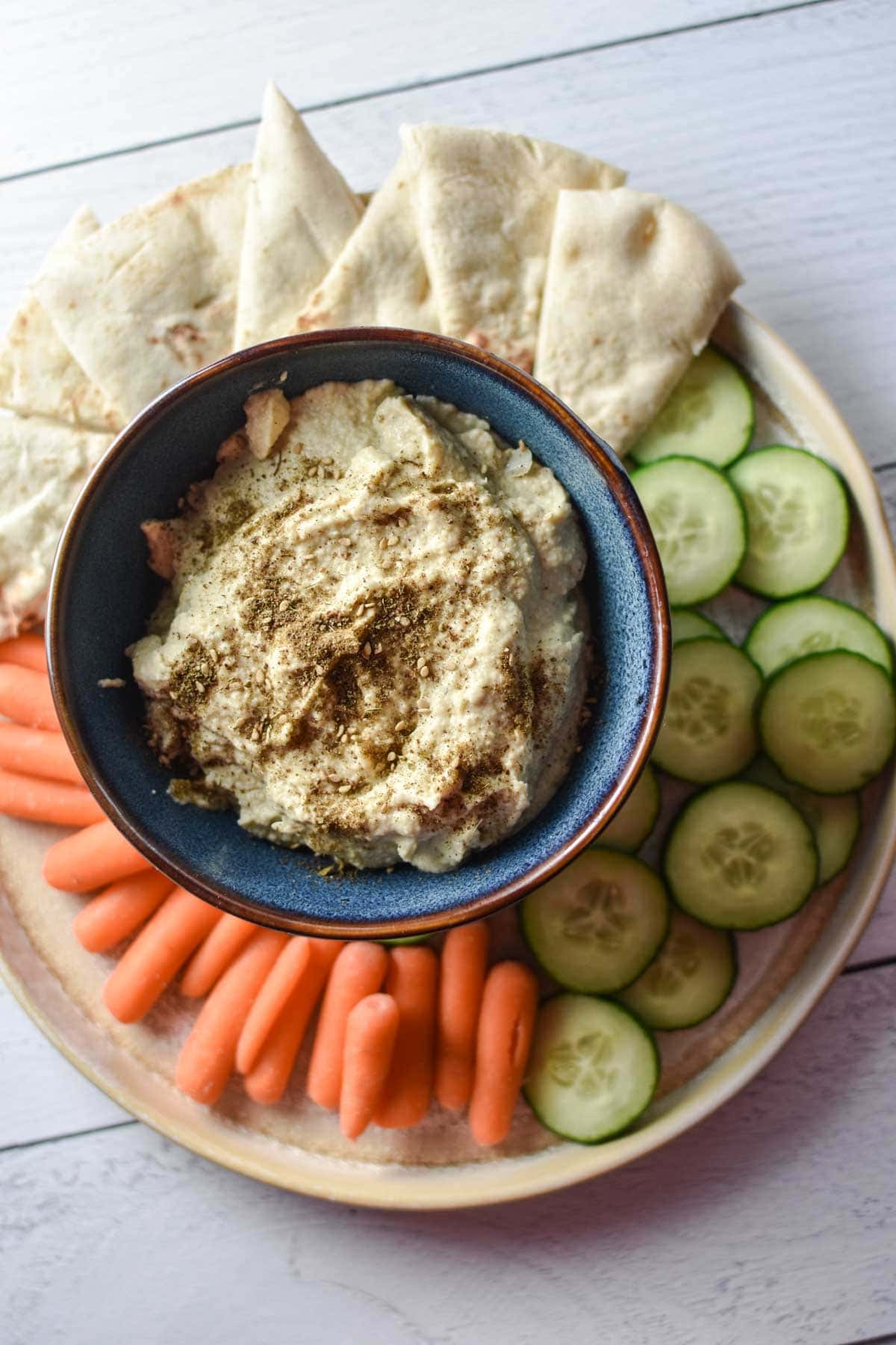 Artichoke hummus on a platter with appetizers.
