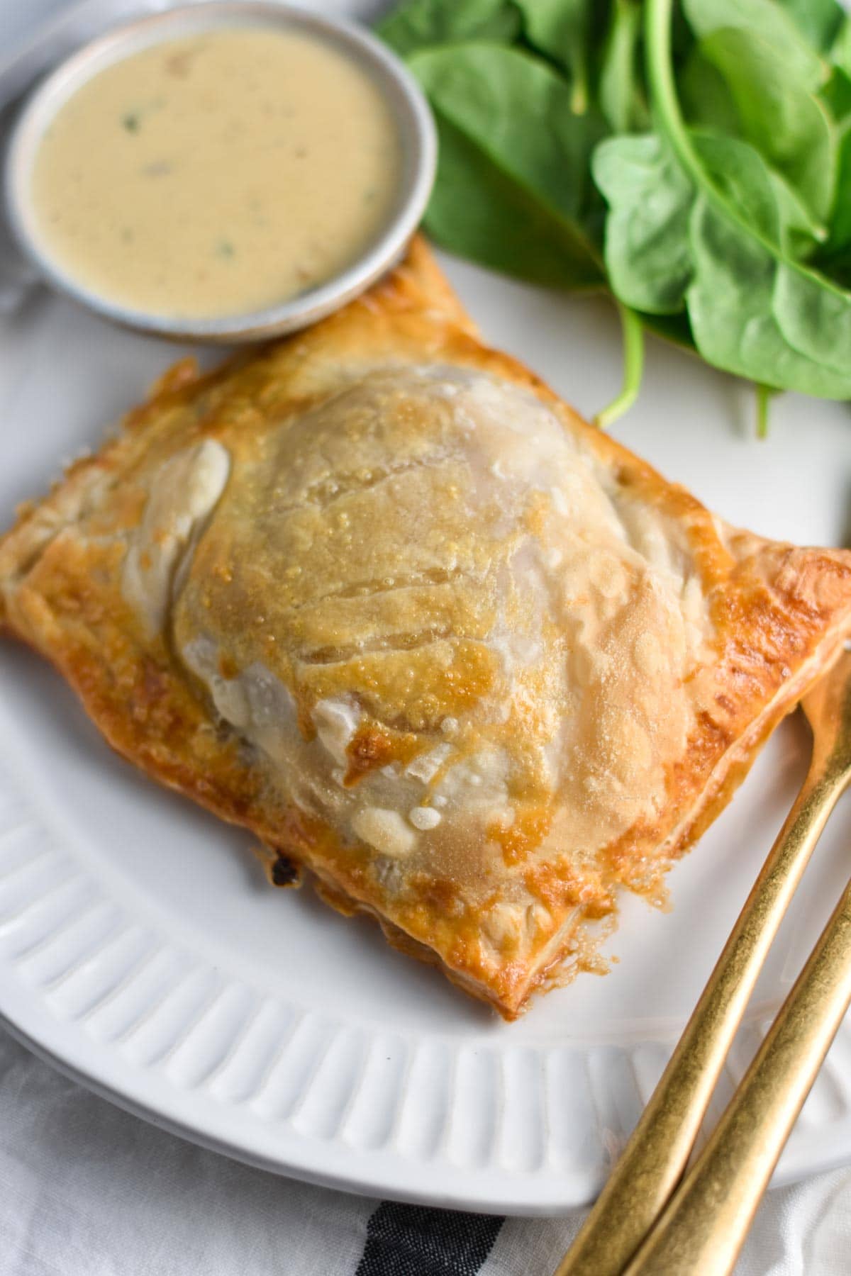 A chicken breast wrapped in puff pastry on a plate. 