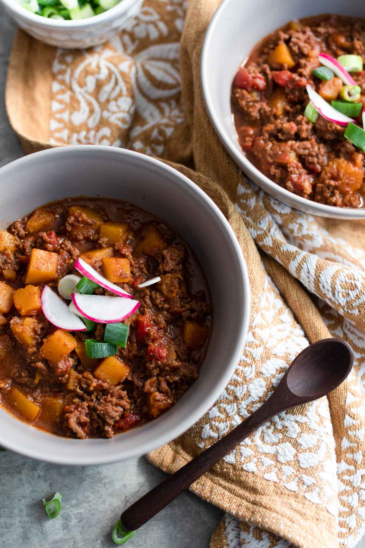 Bowls of chili without beans loaded with toppings.