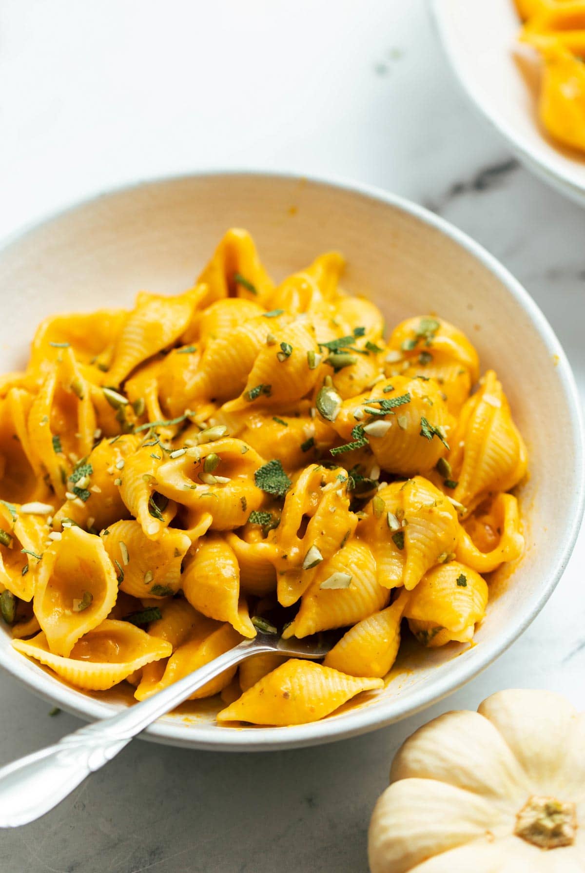 Pumpkin pasta in a bowl with a fork.